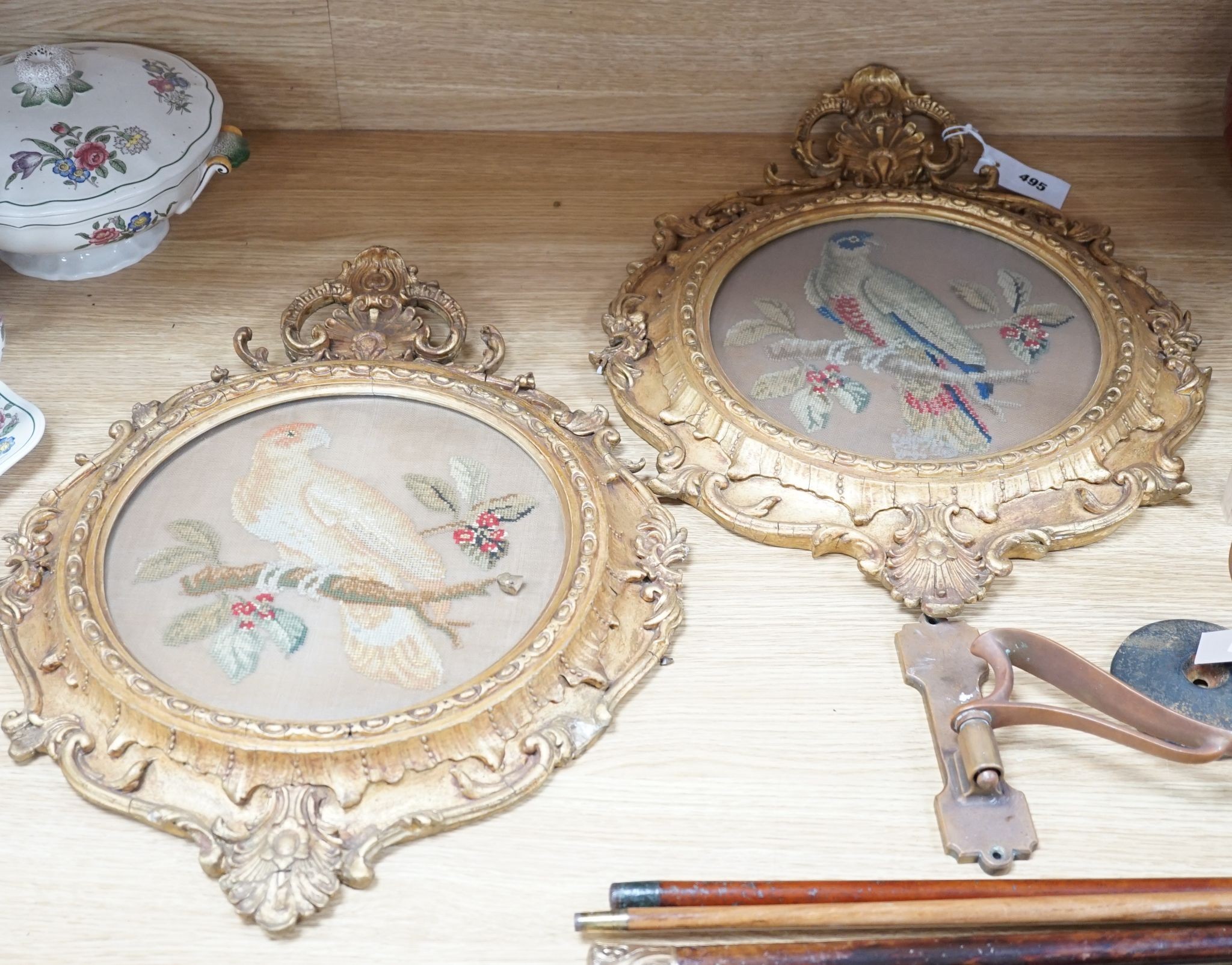 A pair of 19th century giltwood framed circular needleworks of parrots, 26cm diameter excl frame